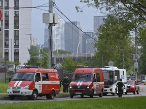 Police and emergency vehicles park at the site of the wreckage of a drone that fell near the Karamyshevskaya embankment in Moscow on Friday, Aug. 11, 2023.