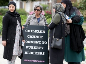 A woman carries a sign objecting puberty blockers for a children at a protest in Ottawa on June 9, 2023. Julie Oliver/Postmedia