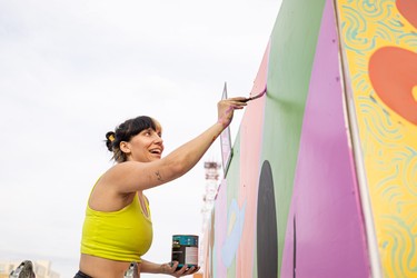 Dakota Ray Hebert paints her mural at the Urban Canvas Street Party in the Midtown parking lot.