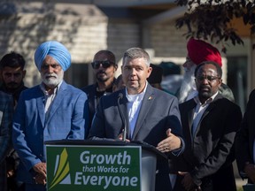 Trade and Export Development Minister Jeremy Harrison stands with community partners and newcomers for an event at the South Leisure Centre on Wednesday, September 28, 2022 in Regina.