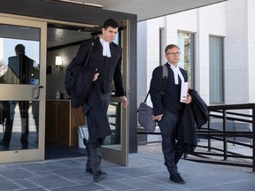 Lawyers Adam Goldenberg, of Toronto-based firm McCarthy Tétrault LLP, left, and Bennett Jensen, legal director at LGBTQ+ lobby group Egale Canada, right, walk out of the Court of Kings Bench after meeting with a judge regarding legal action against Saskatchewan's preferred pronoun policy on Monday, September 18, 2023 in Regina.