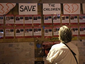 A woman in Tel Aviv looks at a wall bearing the portraits of those kidnapped during the Oct. 7 Hamas attack on Israsel.