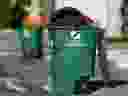 周一早上，在斯通布里奇，一个未正确装载黑色垃圾袋的绿色垃圾箱没有被捡到。 照片摄于萨斯喀彻温省萨斯卡通。  2023 年 10 月 30 日星期一。