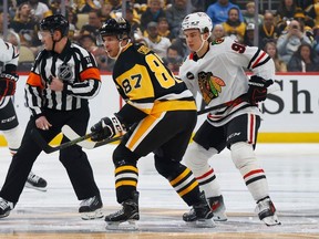 Connor Bedard #98 of the Chicago Blackhawks faces off against Sidney Crosby #87 of the Pittsburgh Penguins during the first period at PPG PAINTS Arena on October 10, 2023 in Pittsburgh, Pennsylvania.