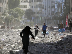 Palestinians leave their homes following Israeli bombardment on Gaza City, Monday, Oct. 30, 2023.