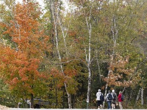 People walk in Saint-Benoit-du-Lac, Que. on Friday, Oct. 6, 2023.