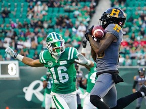 Hamilton Tiger-Cats receiver Omar Bayless (80) catches the football as Saskatchewan Roughriders defensive back Amari Henderson (16) defends during the first half of CFL football action at Mosaic Stadium in Regina, on Saturday, October 7, 2023.