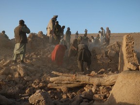 Afghan residents clear debris from a damaged house after earthquake in Sarbuland village of Zendeh Jan district of Herat province on Oct. 7, 2023.