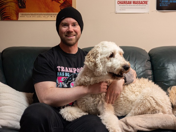  Adam Pottle, an author, academic and Deaf/disability advocate who just published his latest book, a horror novel, is shown at his Saskatoon home with his golden doodle, Valkyrie in Saskatoon.
