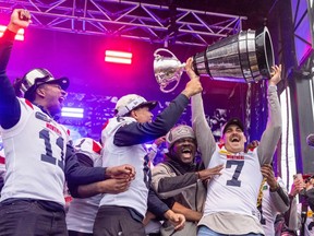 Montreal Alouettes Cody Fajardo raises the Grey Cup while celebrating onstage with team-mates Kaion Julien-Grant, left, Tyson Philpot and Jeshrun Antwi after their parade in Montreal Wednesday November 22, 2023.