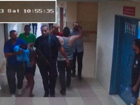 This screen grab taken from security camera footage released by the Israeli army shows Hamas fighters leading hostages into Al-Shifa Hospital on Nov. 7.