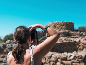 A tourist photographs a nuraghe site in Arzachena, Sardinia, in this file photo.