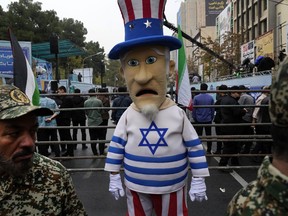 An Iranian man wears Uncle Sam costume with Israeli flag during a rally in front of the former U.S. Embassy in Tehran, Iran, marking 44th anniversary of the seizure of the embassy by militant Iranian students, Saturday, Nov. 4, 2023.