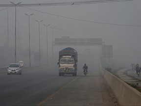 Vehicles move on a highway as smog envelops the areas of Lahore, Pakistan, Wednesday, Nov. 8, 2023.