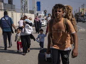 Palestinians arrive at Rafah, the border crossing between the Gaza Strip and Egypt, on Wednesday, Nov. 1, 2023