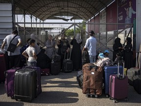 Palestinians wait to cross into Egypt at Rafah, Gaza Strip, on Wednesday, Nov. 1, 2023.