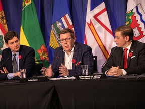 Scott Moe, centre, Premier of Saskatchewan, speaks during a press conference at the meeting of the Council of the Federation, where Canada's provincial and territorial leaders meet, in Halifax, Monday, Nov. 6, 2023.