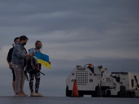 Ukrainian refugees arrive in Regina from a humanitarian flight out of Warsaw, Poland, and stand on the tarmac before walking into customs at Regina International Airport in July 2022.
