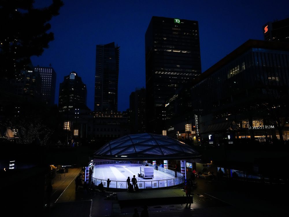 A worker uses a Zamboni to resurface the ice as people wait to skate at the Robson Square ice rink in downtown Vancouver, on Saturday, Jan. 14, 2023.