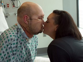 In this undated image released by NYU Langone Health, Aaron James kisses his wife Meagan while he recovers from the first whole-eye and partial face transplant, at NY Langone Health in New York.