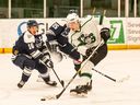 Huskies defenceman Parker Gavlas attempts to beat the Mount Royal University Cougars defence in Saskatoon on Dec. 1.