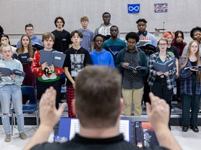 Shaun Bzdel leads the St. Joseph high school choir in a rehearsal while they prepare to perform the music of Queen with the SSO.