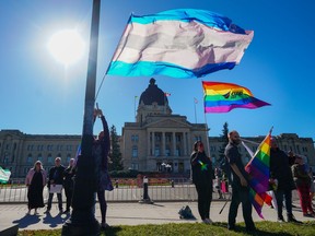 People hold pride flags while attending a rally against the Saskatchewan government's legislation on pronouns in schools, in front of Saskatchewan legislature in Regina, on Tuesday, Oct. 10, 2023.