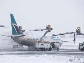 WestJet flight 195 to Victoria is de-iced before takeoff from Calgary on Tuesday, January 16, 2024. WestJet was recovering from flight cancellations over the weekend during the recent severe cold weather.