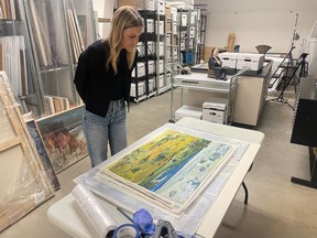Leah Taylor peruses the collection of Wynona Mulcaster artworks at the Mann Art Gallery in Prince Albert, Sask., in 2023.