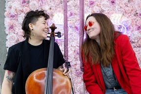 Emma Jean and Stacey Dunn of Cupid's Heart are photographed in front of a flower wall at The Shoppe downtown Saskatoon.