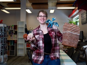 Brianna Redlich, Owner and Operator of Yarn Over Fibre & Crafting Co., displays a knitting project while standing for a photograph in Regina on Monday, January 8, 2024.