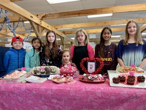 Young bakers stand with their Valentines-themed creations at the Saskatoon Farmer's Market on February 11, 2024.