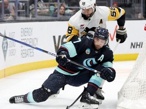 SEATTLE, WASHINGTON - FEBRUARY 29: Kris Letang #58 of the Pittsburgh Penguins defends Jordan Eberle #7 of the Seattle Kraken during the second period at Climate Pledge Arena on February 29, 2024 in Seattle, Washington.