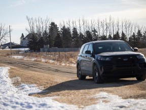 An RCMP vehicle is stationed outside a farmhouse near the town of Neudorf on Tuesday, March 26, 2024, a day after RCMP announced an investigation into the suspicious deaths of four people found in a rural residence in the area was underway.