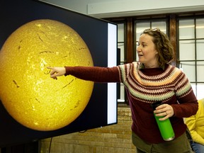 Dr. Carley Martin points out sun spots on the sun before the clouds hinder the partial solar eclipse at the University of Saskatchewan observatory.