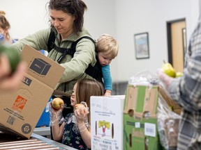 Terri Lynn and her children pack boxes of food during the last run of the CHEP Good Food Box program.