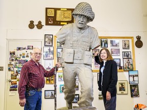 Don and Shirley Begg pose with a clay version of their Regina Rifleman sculpture at Studio West Bronze Foundry in Cochrane, Alta. on Thursday, May 23, 2024. The final 8-foot-tall bronze statue will be unveiled in Normandy ahead of the D-Day 80th anniversary. (Photo by Steven Wilhelm/Postmedia)