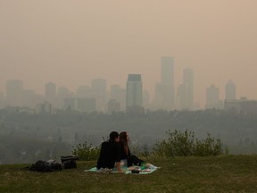 Last year's record-breaking wildfire season forced Canadians to become familiar with the scale of air pollution as hazardous smoke drifted across the country. Smoke from wildfires blankets the city as a couple has a picnic in Edmonton, Saturday, May 11, 2024.