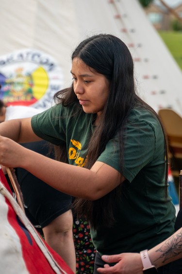 Alexi Sylvester secures the canvas when setting up a teepee with the Reconciliation Saskatoon teepee raising team before the Rock Your Roots walk at Victoria Park in Saskatoon, Sask., on Thursday, June 20, 2024.