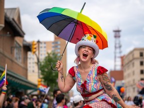 Lauretta Peters hold an umbrella during pride parade in downtown Saskatoon, Sask., on Saturday, June 22, 2024.