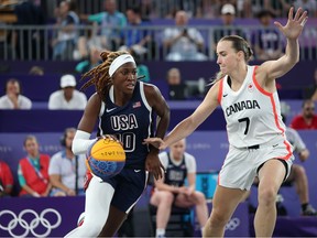 Rhyne Howard #10 of Team United States drives past Paige Crozon #7 of Team Canada during a women's 3x3 basketball bronze medal game between the United States and Canada at the Olympic Games Paris 2024 at Esplanade Des Invalides on August 05, 2024 in Paris, France.