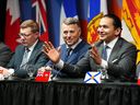 Manitoba Premier Wab Kinew speaks at a press conference concluding a first ministers meeting, in Ottawa on Jan. 15, 2025, next to Saskatchewan Premier Scott Moe (left) and Prince Edward Island Premier Dennis King.