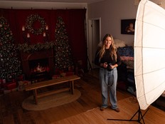 A photographer stands by her umbrella light.
