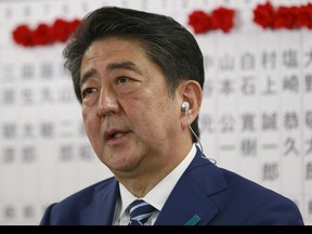 Japanese Prime Minister Shinzo Abe, leader of the Liberal Democratic Party, answers a question from reporter during a TV interview on the ballot counting of the parliamentary lower house election at the party headquarters in Tokyo, Sunday, Oct. 22, 2017. Japanese media projected shortly after polls closed that Prime Minister Shinzo Abe's ruling coalition would win a clear majority in national elections.(AP Photo/Shizuo Kambayashi)