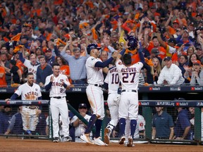 Yuli Gurriel #10 of the Houston Astros celebrates with Carlos Correa #1 and Jose Altuve #27 after hitting a three run home run during the fourth inning against the Los Angeles Dodgers in game five of the 2017 World Series at Minute Maid Park on October 29, 2017 in Houston, Texas.  (Photo by Jamie Squire/Getty Images)