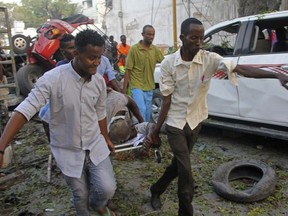 Somalis carry away the wounded civilian who was injured in a car bomb that was detonated in Mogadishu, Somalia Saturday, Oct 28, 2017.  (AP Photo/Farah Abdi Warsameh)