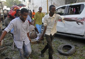 Somalis carry away the wounded civilian who was injured in a car bomb that was detonated in Mogadishu, Somalia Saturday, Oct 28, 2017.  (AP Photo/Farah Abdi Warsameh)