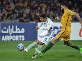 Taiseer al Jassam of Saudi Arabia fights for the ball with Mile Jedinak of Australia during the World Cup football Asian qualifying match between Australia and Saudi Arabia at the Adelaide Oval in Adelaide on June 8, 2017.