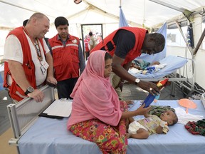 Secretary General of the International Federation of Red Cross and Red Crescent Societies (IFRC) Elhadj As Syat (C) visits a Red Cross clinic treating Rohingya Muslim refugees near Kutupalong refugee camp in the Bangladeshi district of Ukhia on October 25, 2017.
