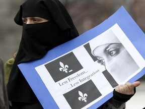 A woman in a niqab protests outside of Montreal City Hall in opposition to Bill 94 on April 17, 2010.